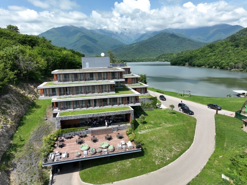 Hotel s terasami ob jezeru med zelenimi hribi